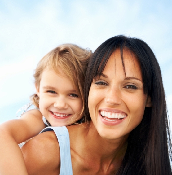 Cute little girl enjoying piggyback ride with mother